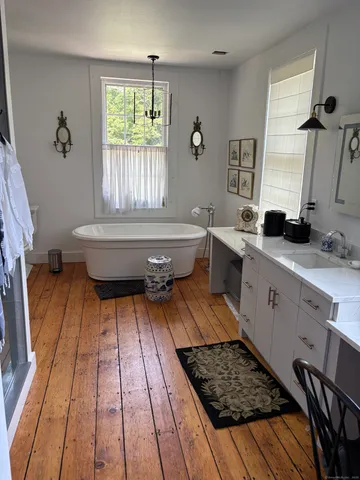 a bathroom with a sink a toilet a window and shower