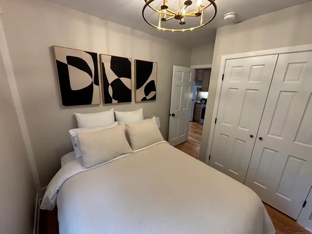 a bedroom with a large bed and a chandelier