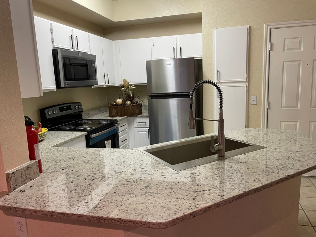 a kitchen with kitchen island sink and refrigerator