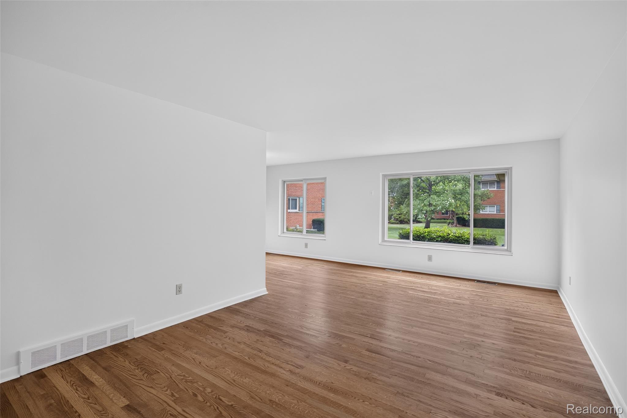 1225 Derby Road, Unit 3 Birmingham, MI 48009 - Photo 3 of 19 Expansive room featuring hardwood flooring and multiple windows