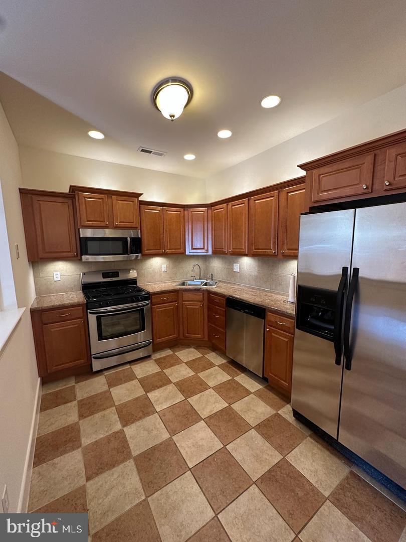 1630 Welsh Road, Unit 3A Philadelphia, PA 19115 - Photo 5 of 14 a kitchen with stainless steel appliances and wood cabinets