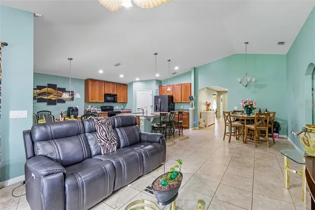 a living room with furniture kitchen and a table