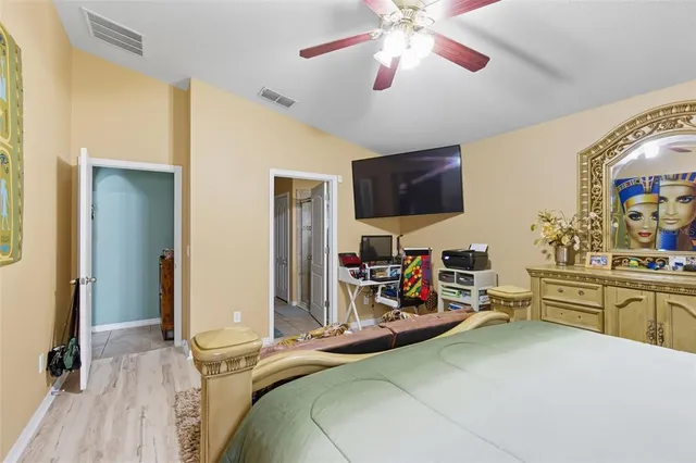 a bedroom with a bed and a flat tv screen on dresser