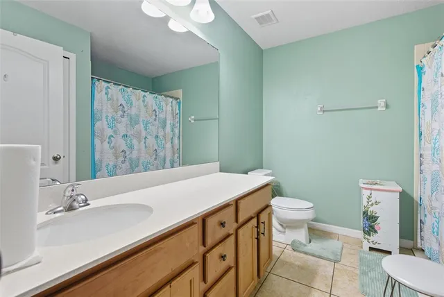 a bathroom with a sink a toilet a mirror and shower