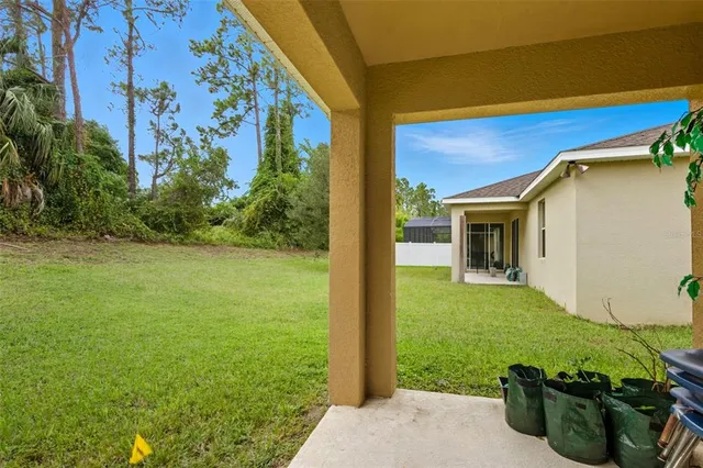 a view of a chair and table in backyard of the house