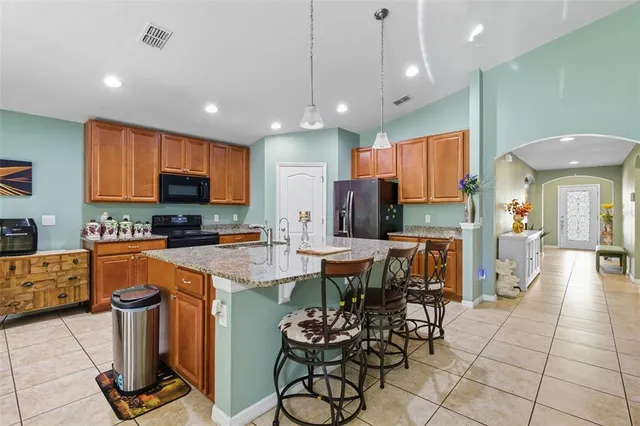 a kitchen with stainless steel appliances granite countertop a stove top oven a sink dishwasher and a refrigerator