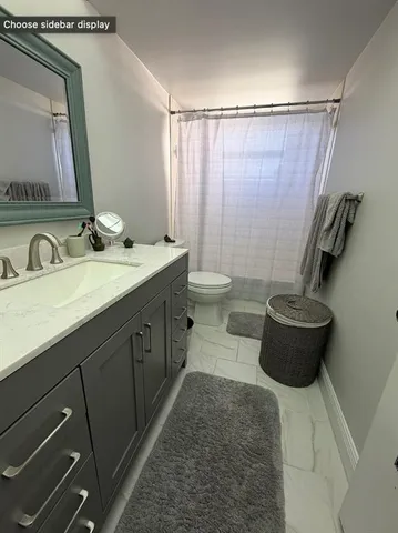 a bathroom with a double vanity sink toilet and shower