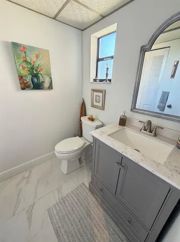 a bathroom with a granite countertop sink mirror vanity and toilet
