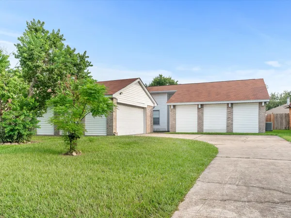 a front view of a house with a yard and trees