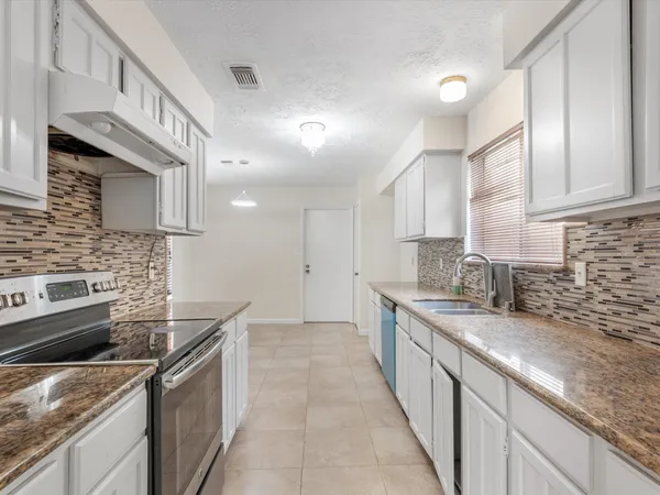 a kitchen with a sink stove and cabinets