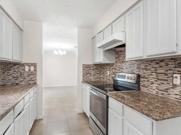 a kitchen with stainless steel appliances granite countertop a sink stove and cabinets