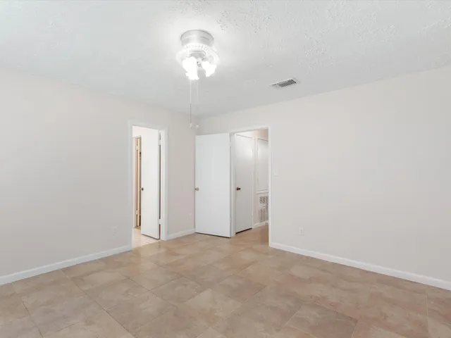 an empty room with a chandelier fan and a chandelier fan