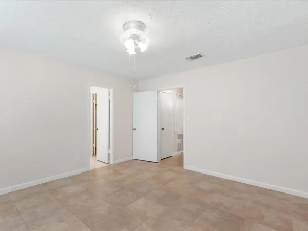 a view of an empty room with a chandelier fan