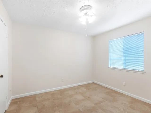 an empty room with a chandelier fan