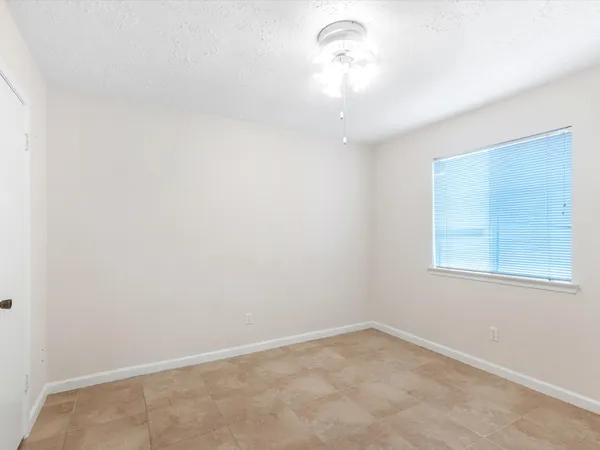 an empty room with a chandelier fan