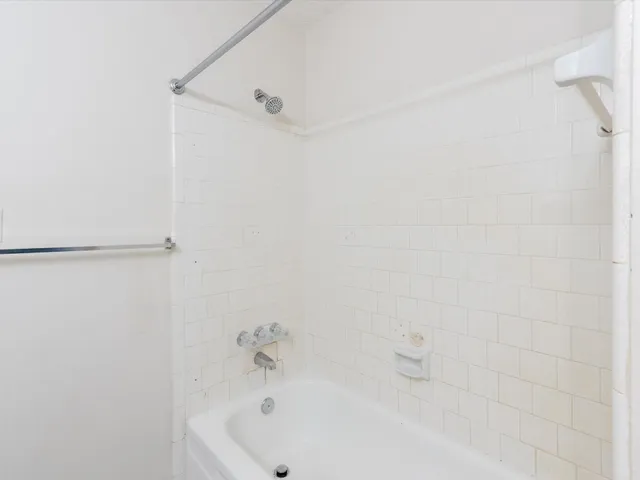 a bathroom with a white bath tub and a shower