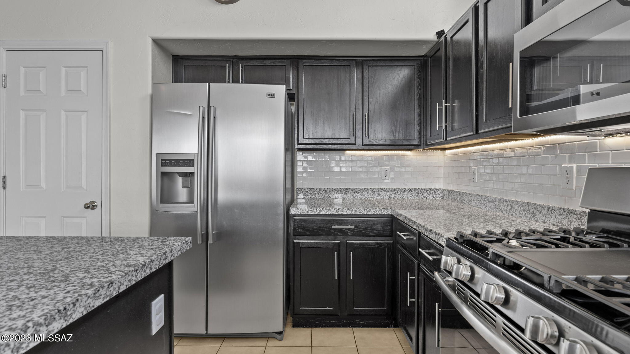 401 Via Capri Rio Rico, AZ 85648 - Photo 22 of 38 a kitchen with granite countertop a stainless steel stove and refrigerator