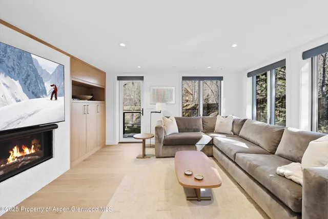 a living room with furniture a flat screen tv and a fireplace