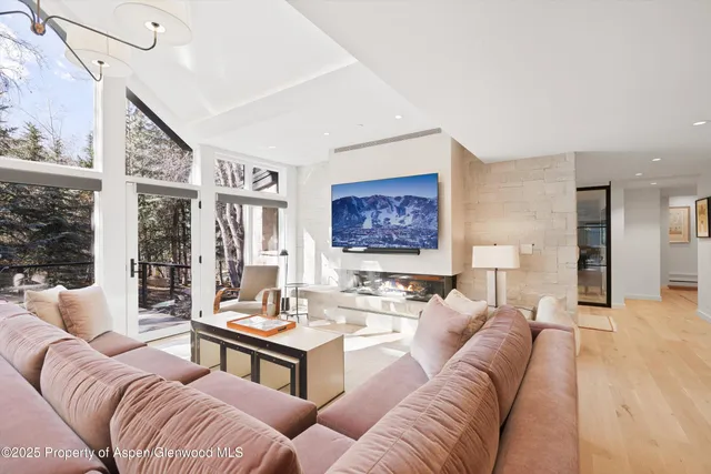 a living room with furniture wooden floor and a large window