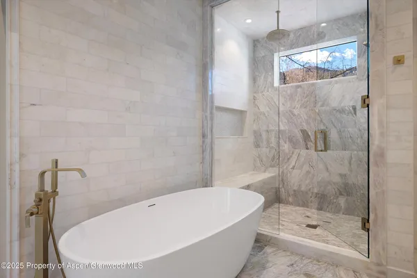 a bathroom with a white bath tub and shower