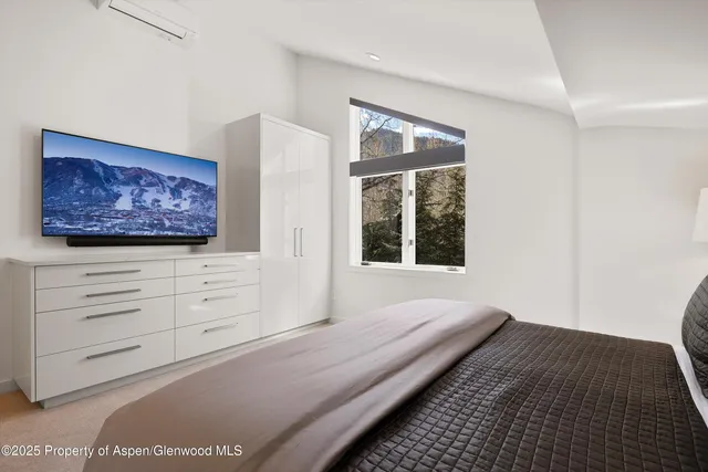 a bedroom with a bed and a painting on the wall