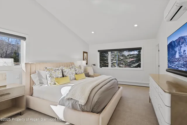 a bedroom with a large bed couch and a window