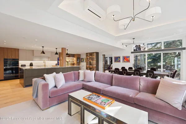 a living room with furniture kitchen view and a large window