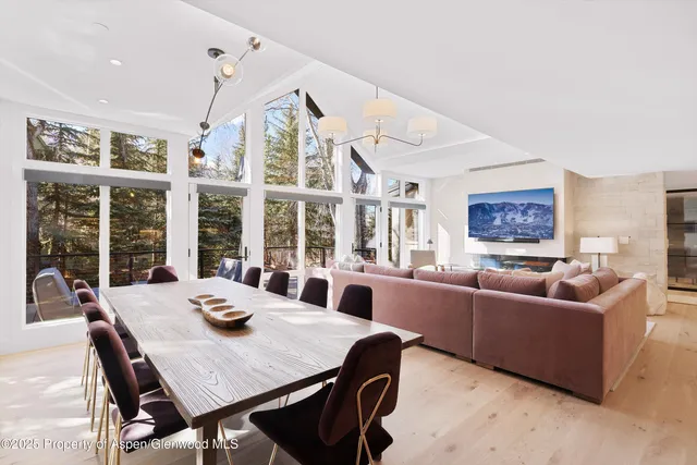a view of a dining room with furniture large windows and wooden floor