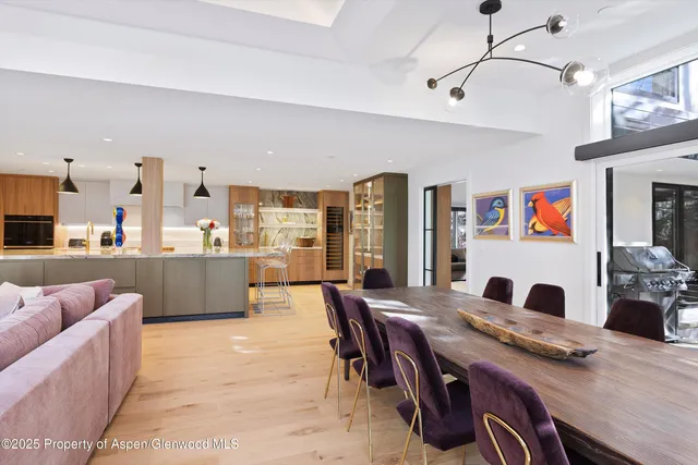 a living room with stainless steel appliances furniture a rug and a kitchen view