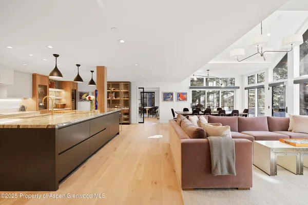 a living room with furniture kitchen view and a large window