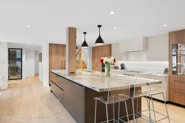 a kitchen with kitchen island granite countertop a sink and cabinets