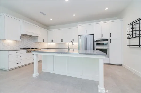 a kitchen with granite countertop white cabinets and stainless steel appliances