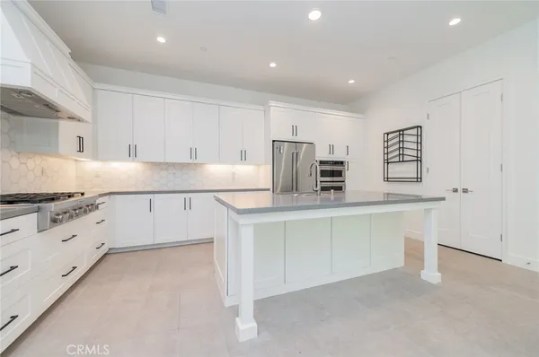 a kitchen with granite countertop white cabinets and white stainless steel appliances