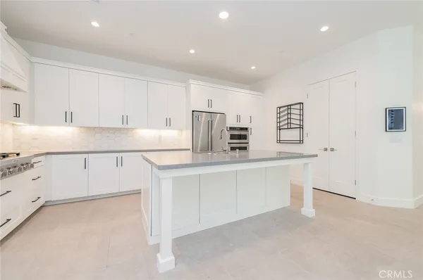 a kitchen with white cabinets and window