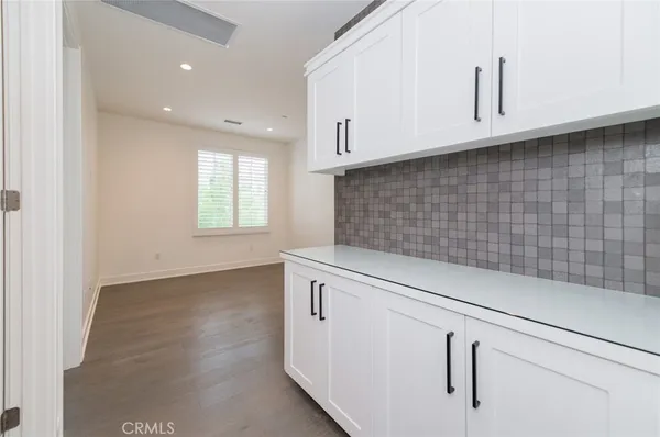 a view of a kitchen with white cabinets