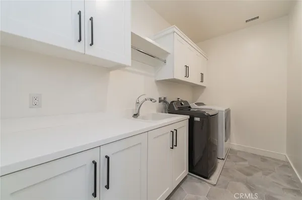 a utility room with sink dryer and washer