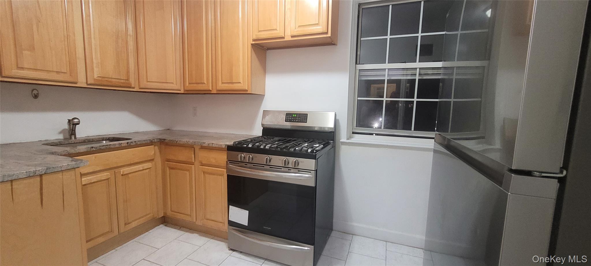 77-04 141st Street, Unit 67F Queens, NY 11367 - Photo 2 of 11 a kitchen with stainless steel appliances granite countertop a stove and a microwave