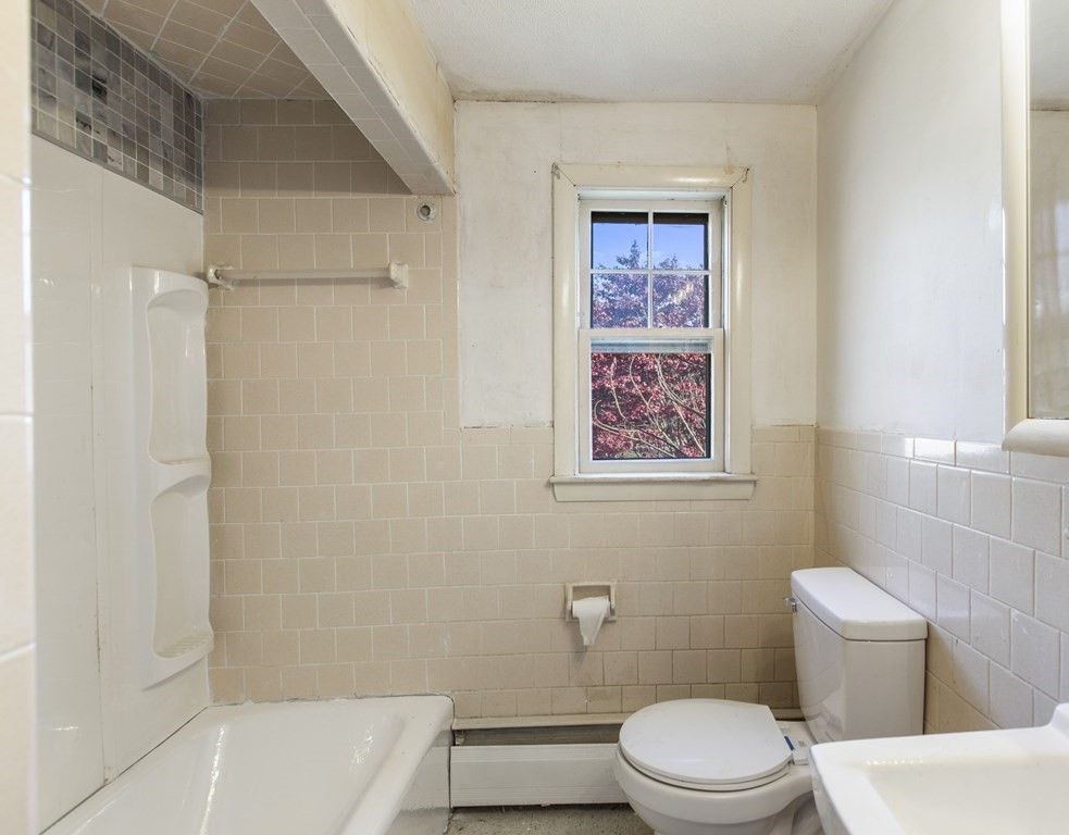 103 Myrtle Street Ashland, MA 01721 - Photo 23 of 38 a white toilet sitting next to a bath tub