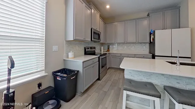 a kitchen with granite countertop a sink appliances and cabinets