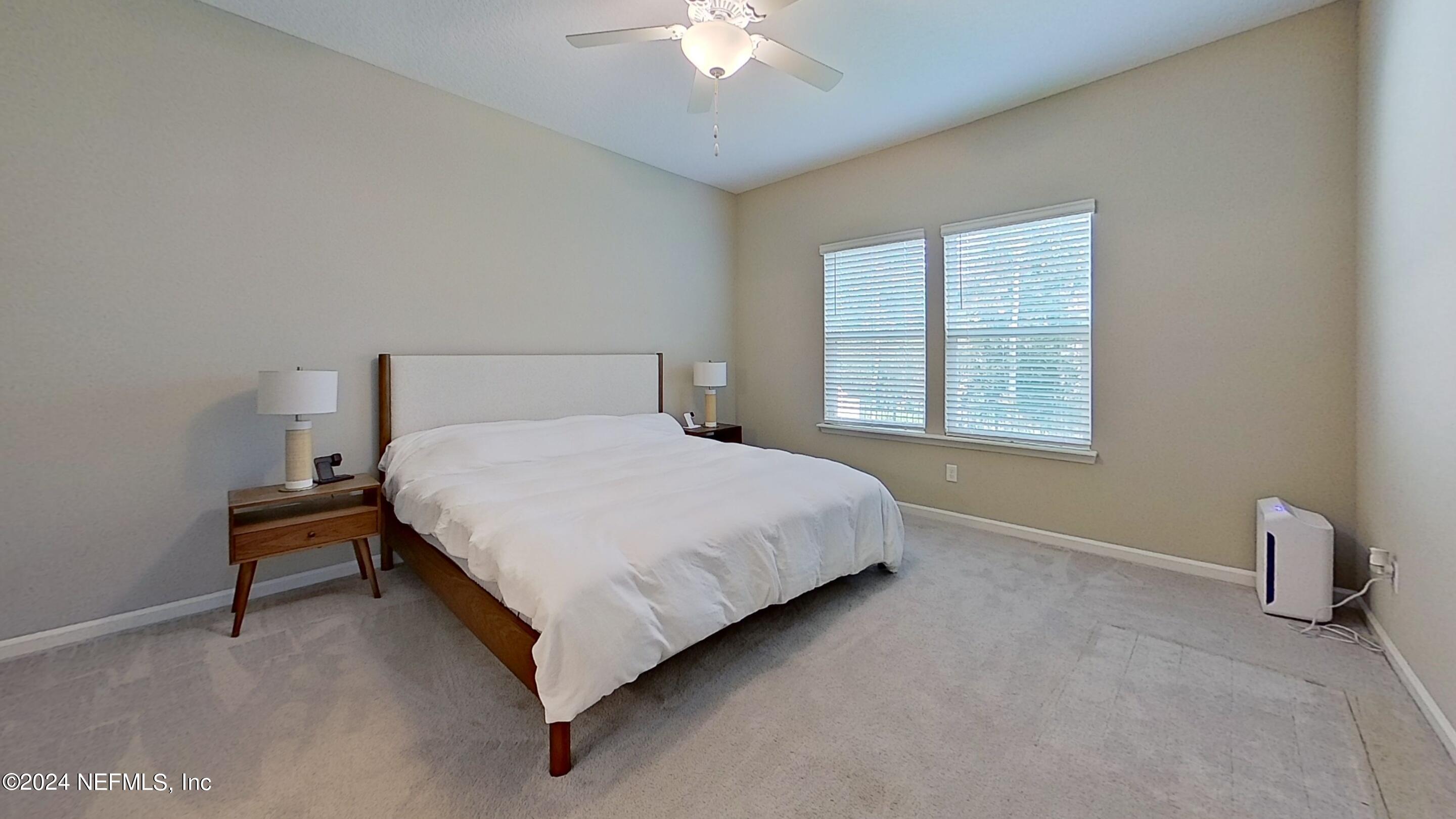 10887 Ventnor Avenue Jacksonville, FL 32218 - Photo 9 of 19 a bedroom with a bed and a chandelier