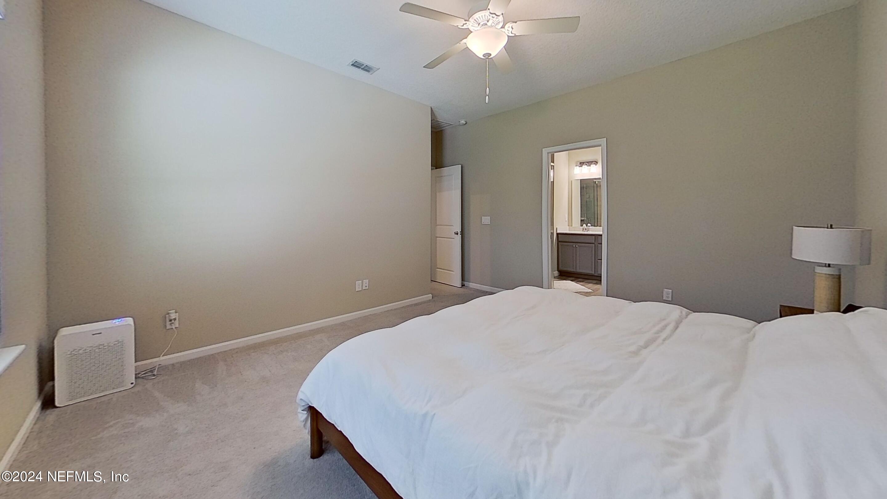 10887 Ventnor Avenue Jacksonville, FL 32218 - Photo 10 of 19 a bedroom with a bed and a chandelier