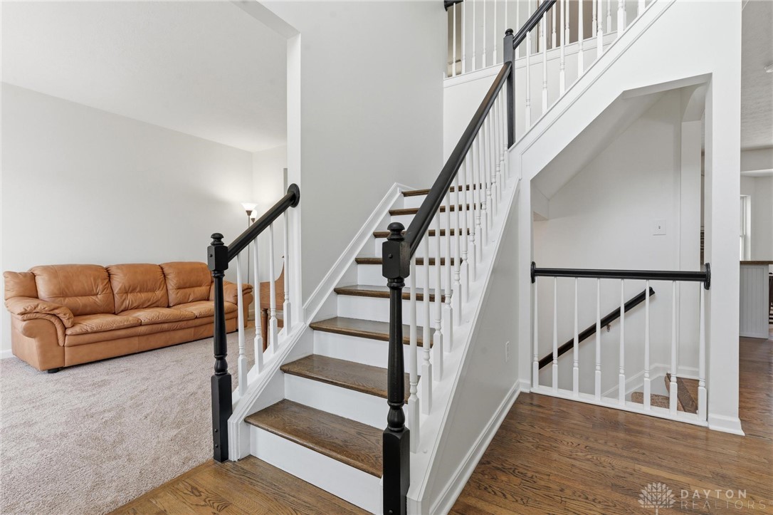 70 Martin Lane Springboro, OH 45066 - Photo 27 of 69 Elegant hardwood flooring leads to a beautifully crafted staircase, creating a warm and inviting atmosphere.