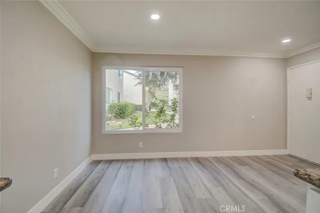 a view of empty room with wooden floor