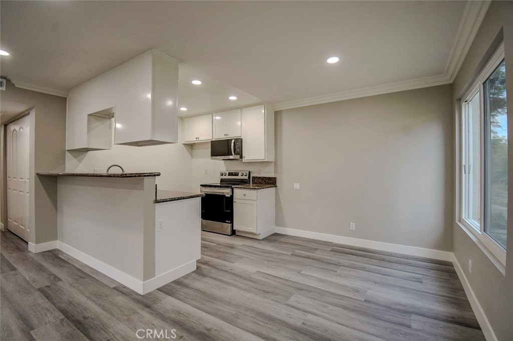 21941 Rimhurst Drive, Unit D Lake Forest, CA 92630 - Photo 2 of 44 a kitchen with granite countertop a stove top oven and cabinets