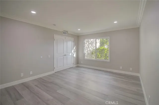 a view of an empty room with wooden floor