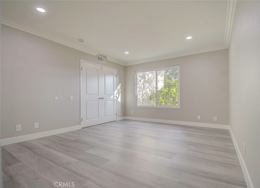 21941 Rimhurst Drive, Unit D Lake Forest, CA 92630 - Photo 30 of 44 a view of an empty room with wooden floor and a window