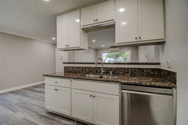 a kitchen with granite countertop white cabinets and a stainless steel appliances
