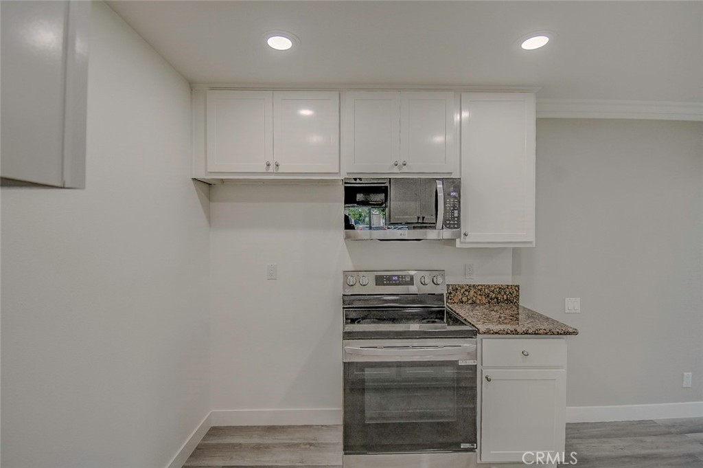 21941 Rimhurst Drive, Unit D Lake Forest, CA 92630 - Photo 6 of 44 a kitchen with a stove and a microwave