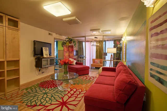 a living room with furniture a window and a flat screen tv