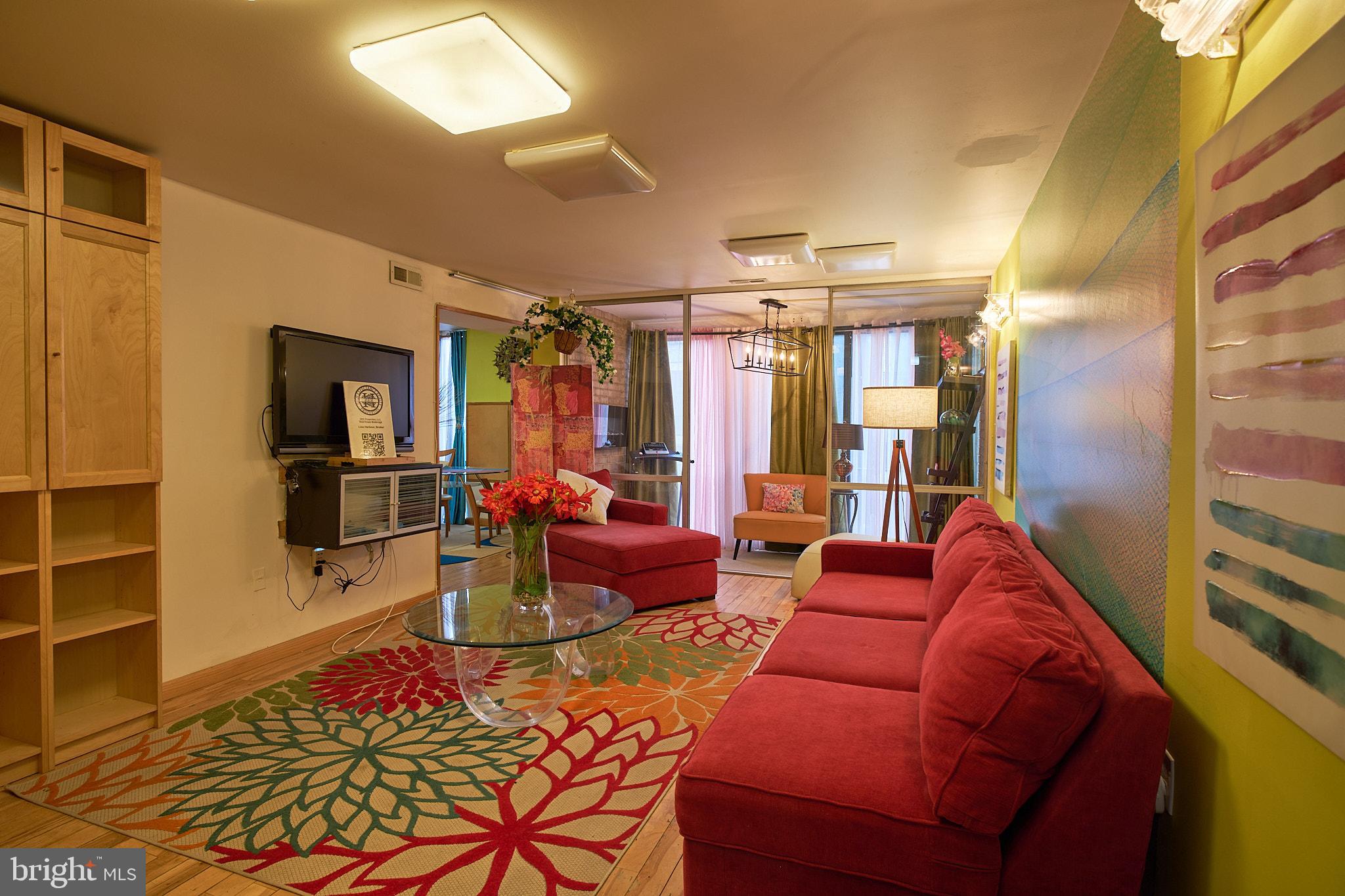 a living room with furniture a window and a flat screen tv